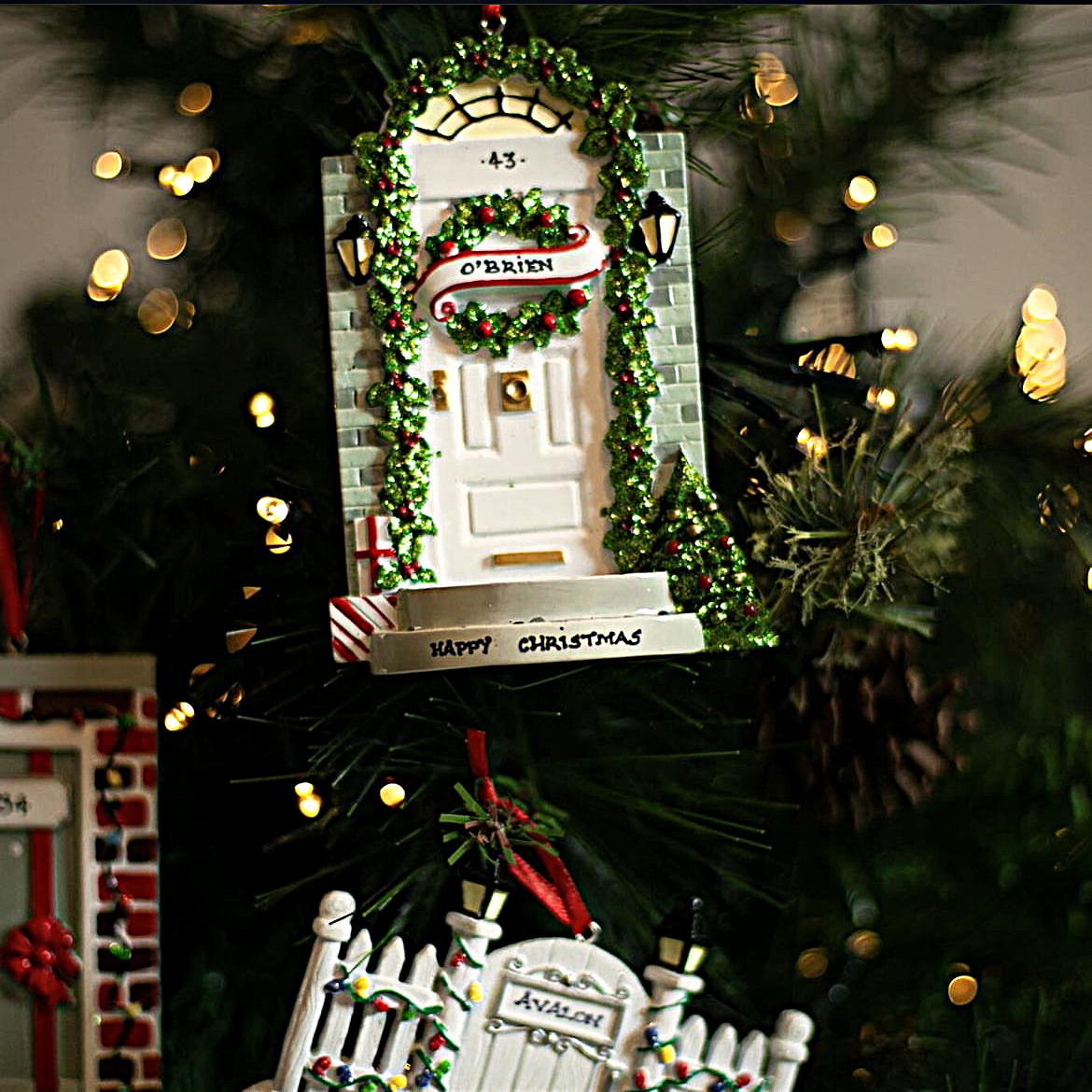 Christmas door ornament decorated with wreath and garland on tree