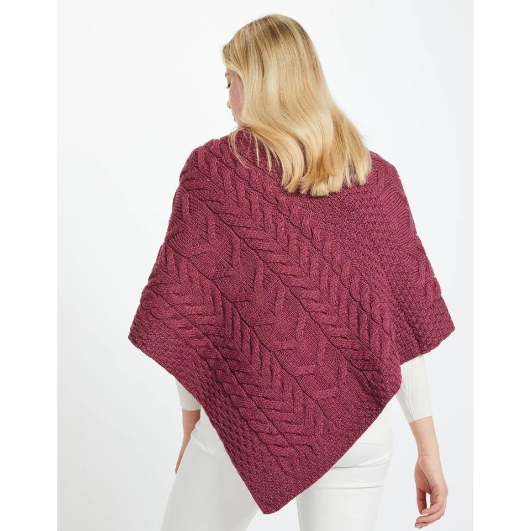 Woman with blonde hair wearing a textured maroon knitted poncho