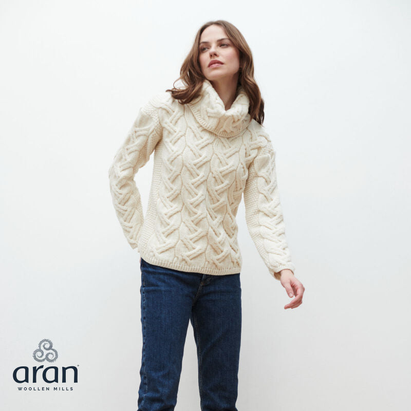 Woman wearing cream cable knit turtleneck sweater and blue jeans