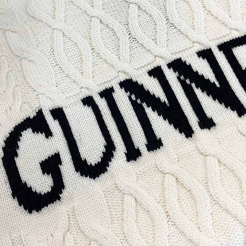 Close-up of white knitted fabric with black letters spelling GUNNAR