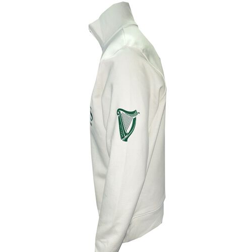 Cream Guinness quarter‑zip fleece shown from side with green crest patch on the sleeve.