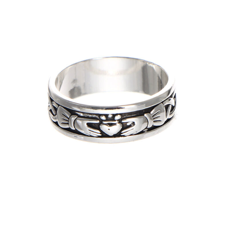 Silver ring with engraved hands holding a heart symbol