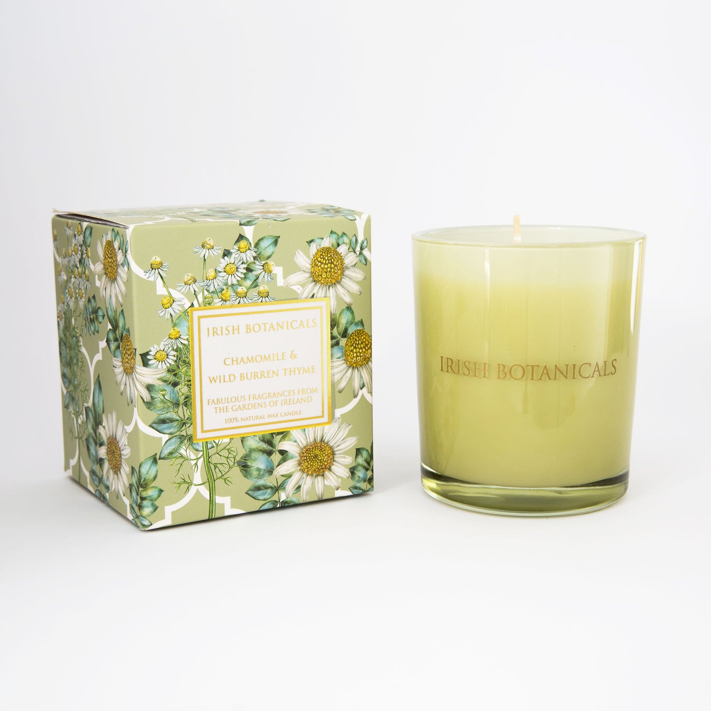 Green glass candle and floral patterned box with chamomile design