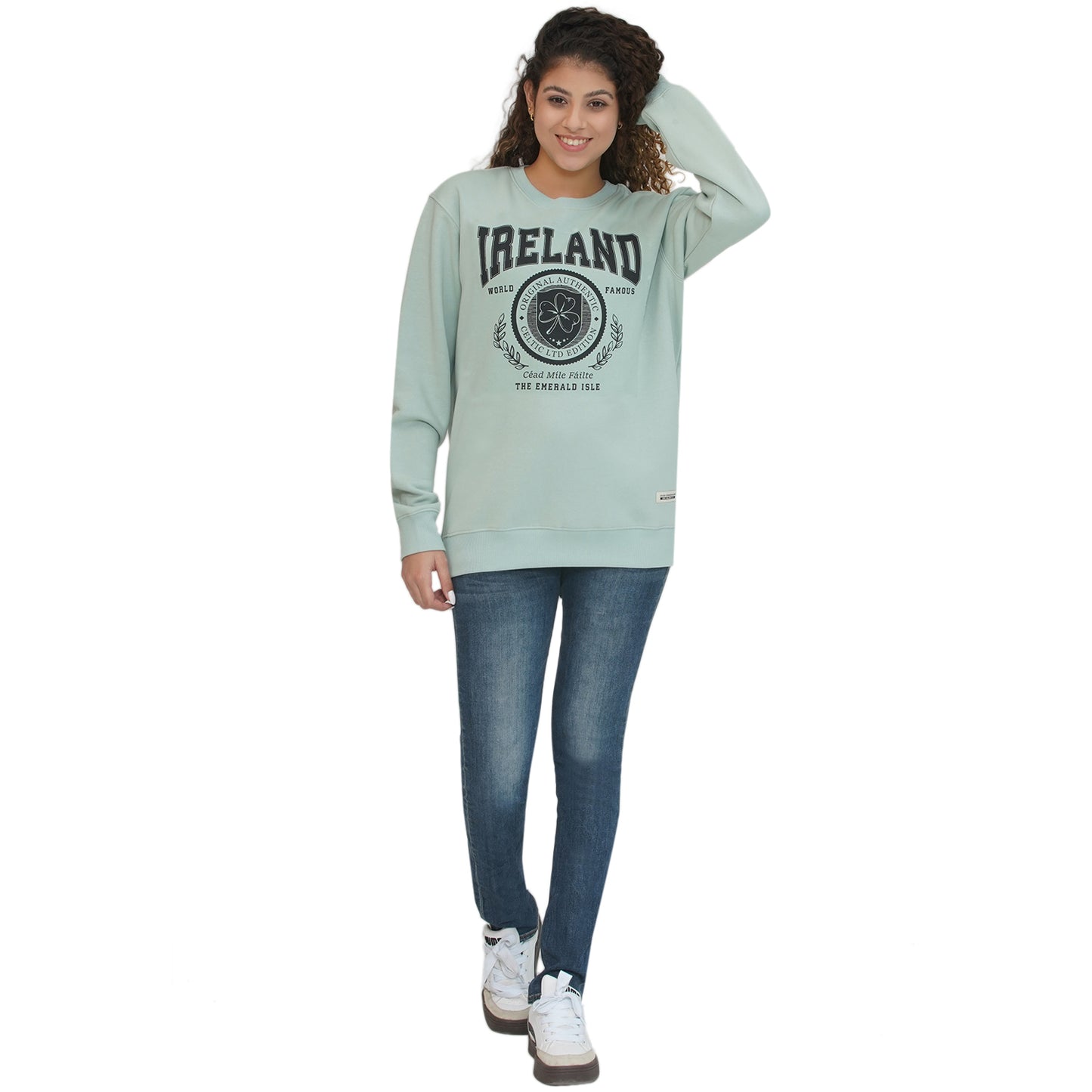 Female model wearing pistachio Ireland badge sweatshirt with crest graphic.