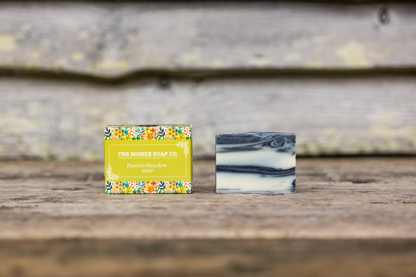 Burren Meadow Natural Soap boxed with bright floral pattern beside a layered marbled soap bar