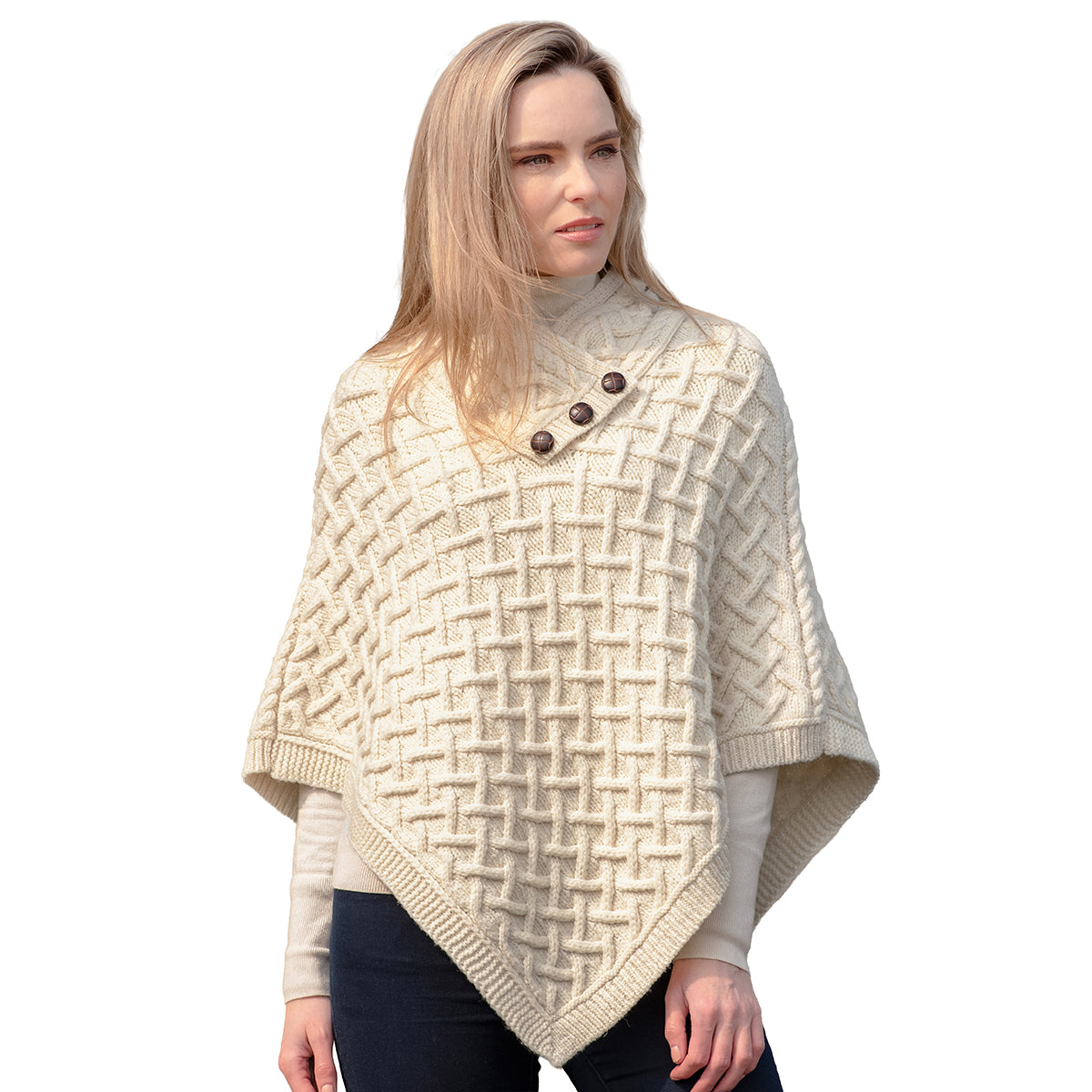 Cream merino poncho with a chunky lattice knit and a buttoned collar worn by a model