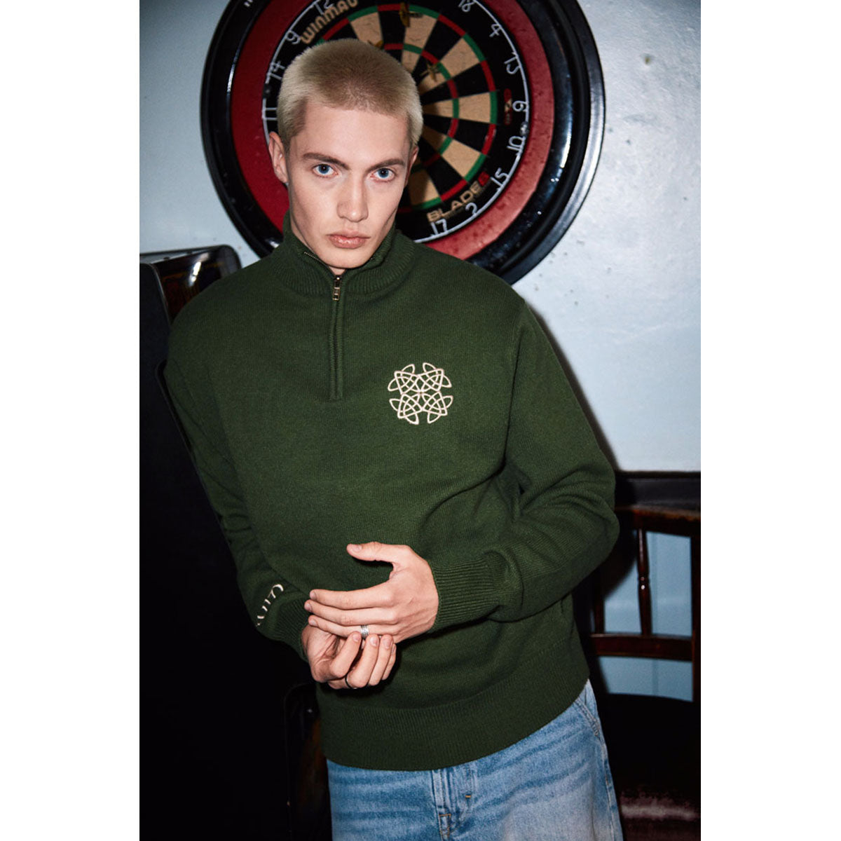 Model wearing sage green Celtic Knot 1/4 zip sweater with a white embroidered logo
