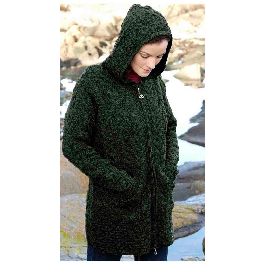 Woman wearing dark green knitted hooded cardigan standing outdoors