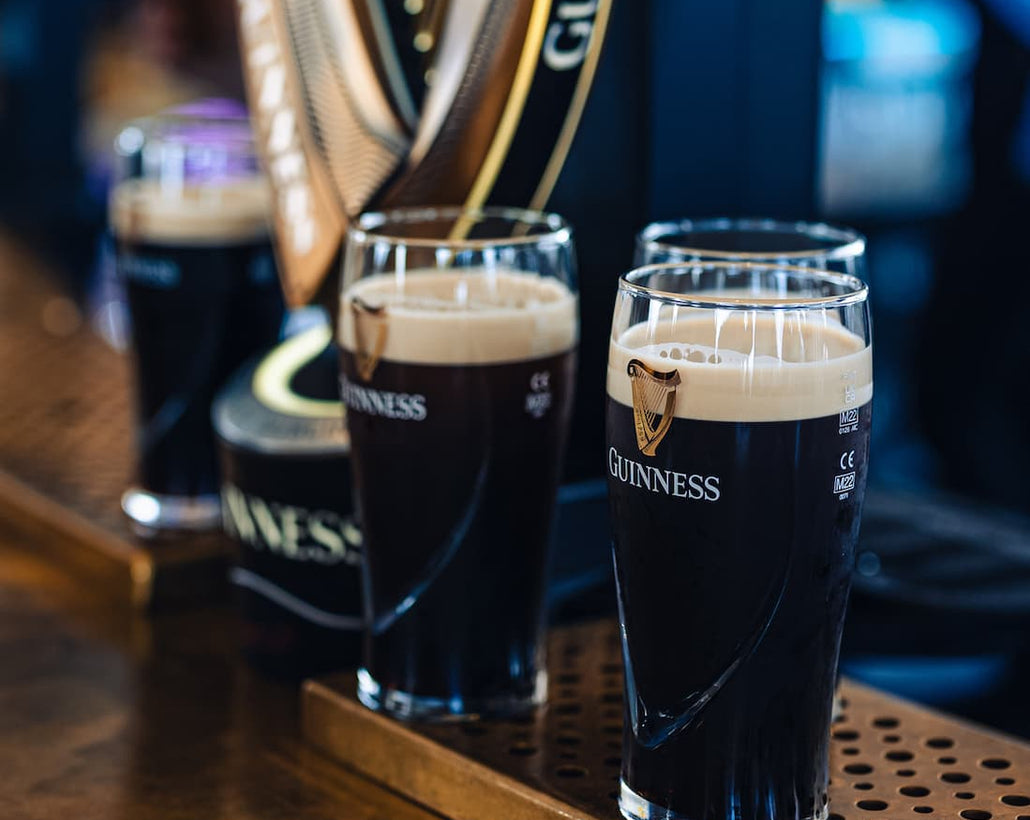 Three pints of Guinness on a bar