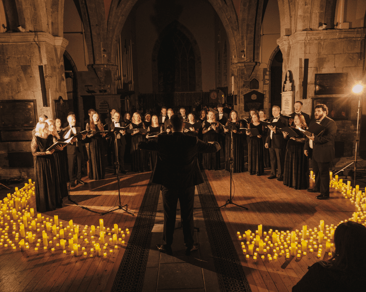 Singers performing in church surrounded by candles 