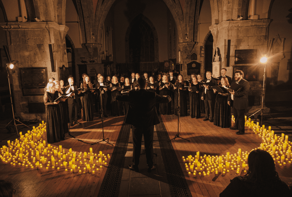 Singers performing in church surrounded by candles 