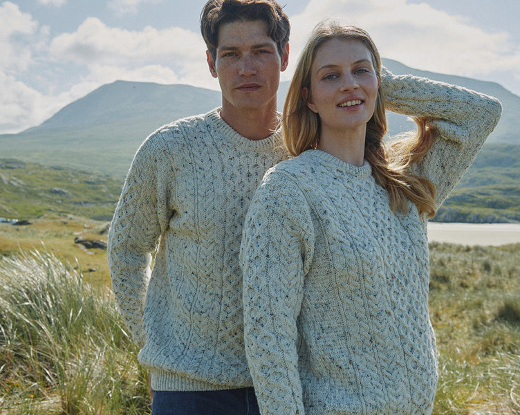 Man and women wearing cream Aran Sweaters