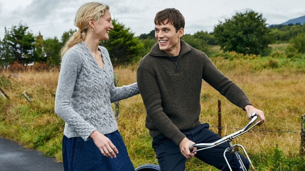 Man riding a bag with a women wearing Aran Sweaters