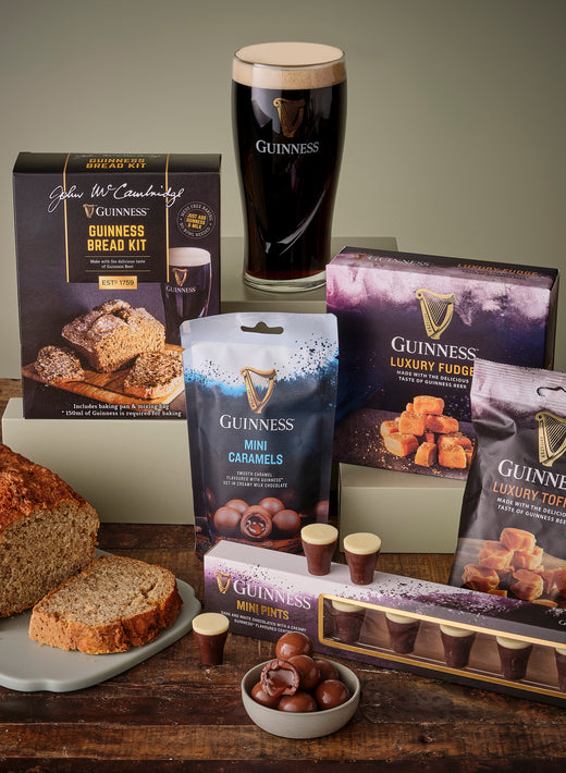 Guinness Treats Gift Basket with bread kit and a selection of snacks arranged on a wooden table