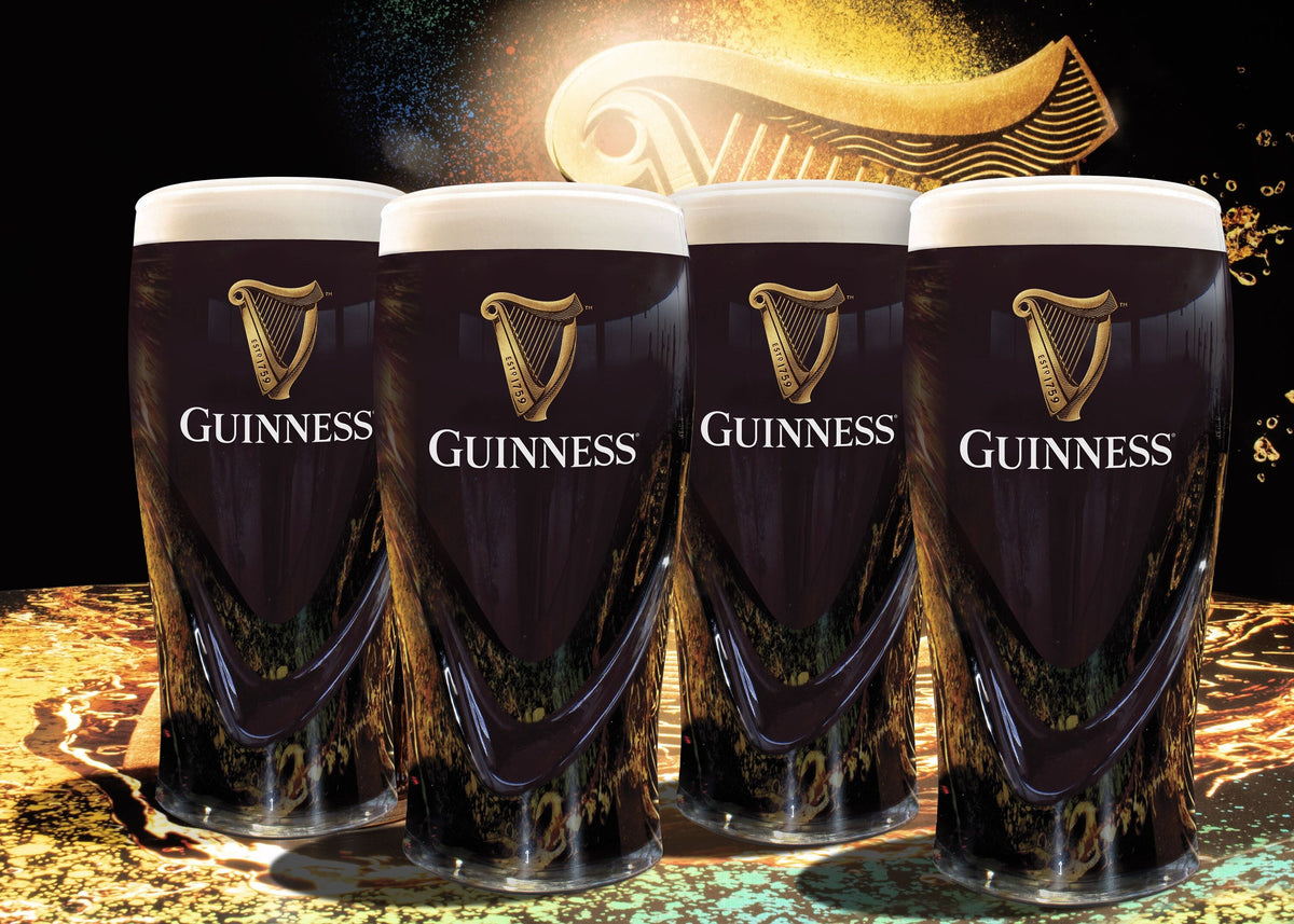 Four pints of dark Guinness beer with creamy foam tops