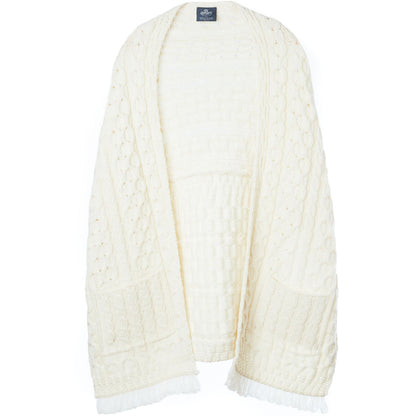 Cream Shannon Throwover Merino Aran wrap laid flat showing cable knit pattern and fringed edges