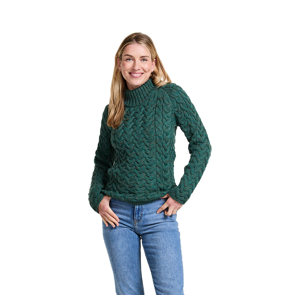 Front view of a smiling woman wearing a green Knightstown Merino Aran Crew sweater