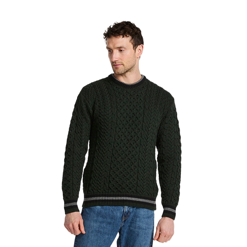 Man wearing a dark green Merino Aran stripe crewneck sweater