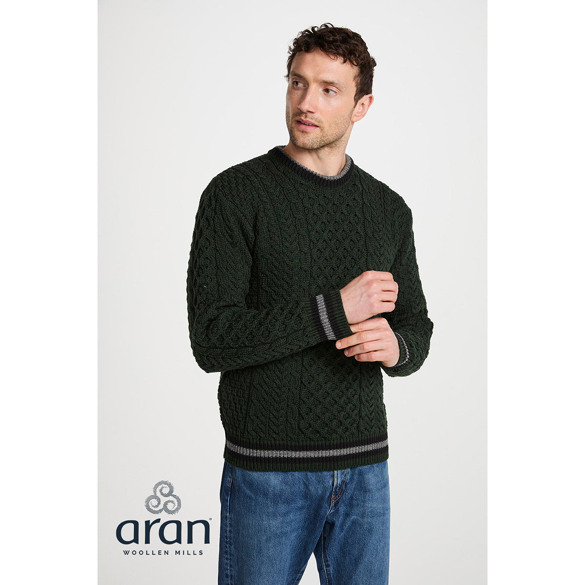 Male model wearing Inishbeg Stripe Crewneck Merino Green Aran Sweater with cable knit pattern