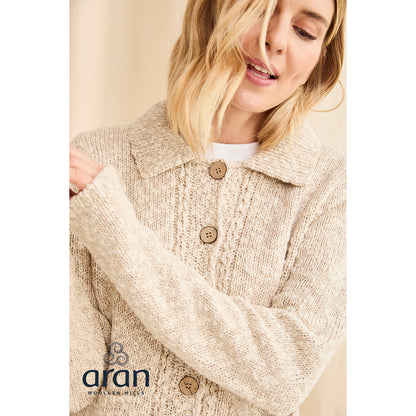 Close up of the cream textured knit cardigan showing wooden buttons and decorative hem.