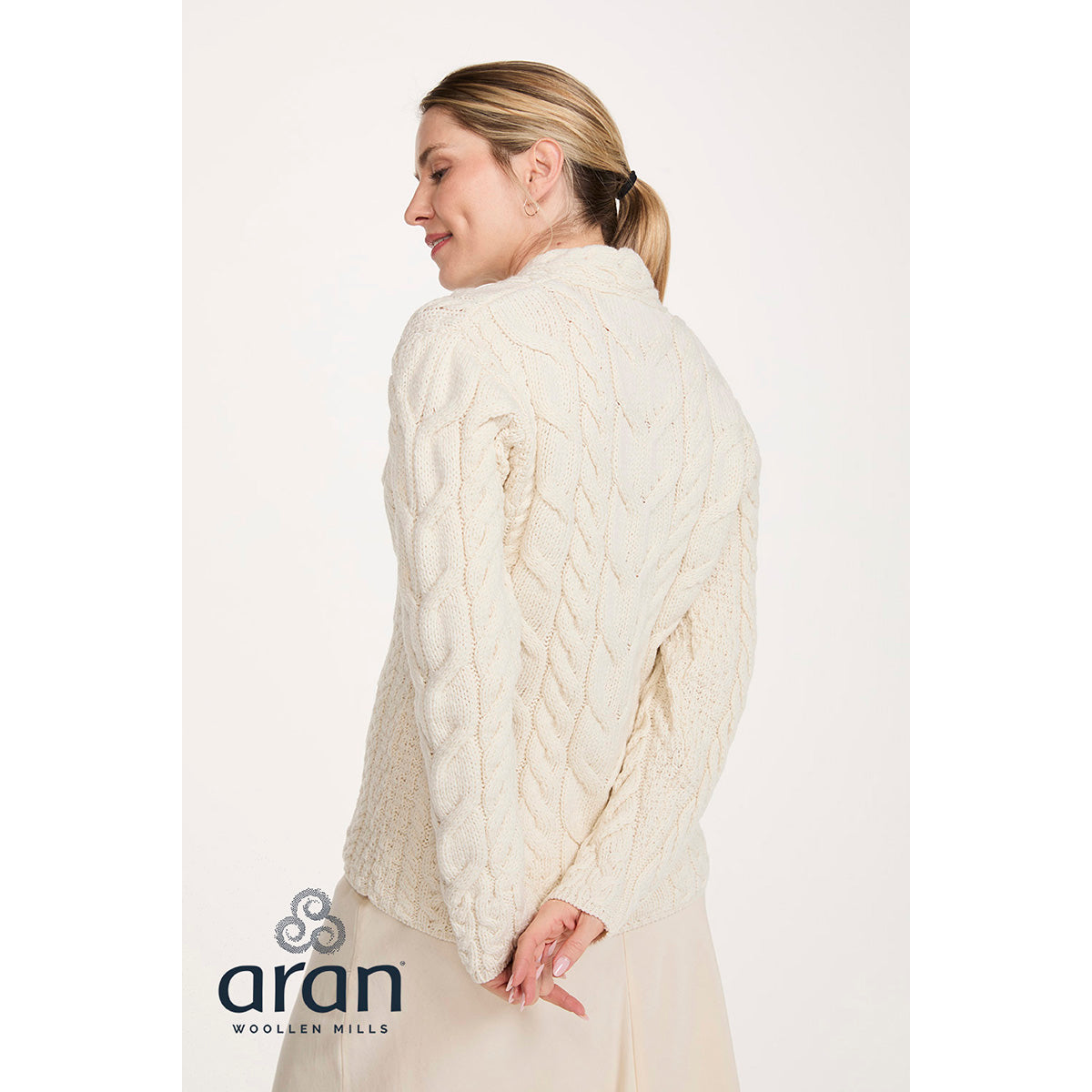 Back view of cream cable knit Merino V-neck sweater on model