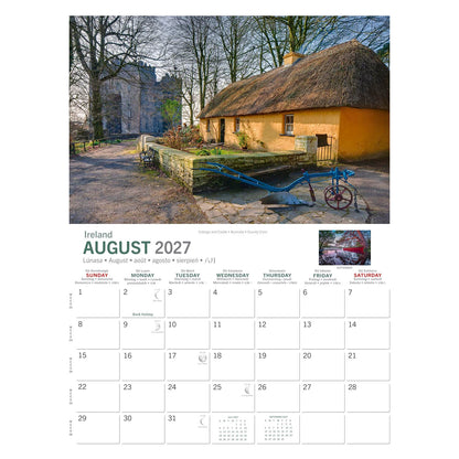 Thatched cottage beside a stone wall with a distant castle, featured on Castles & Cottages Calendar 2027
