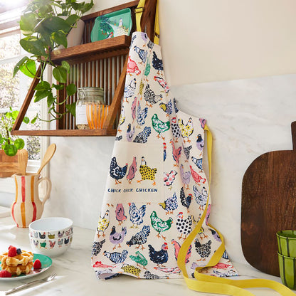 Chick Chicken cotton apron with colorful chicken print hanging in a bright kitchen.