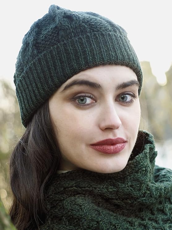Young woman wearing a dark green knit hat and matching scarf outdoors