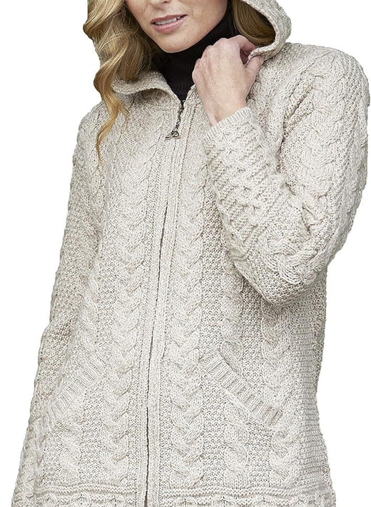 Woman wearing beige cable knit hooded sweater with front pockets