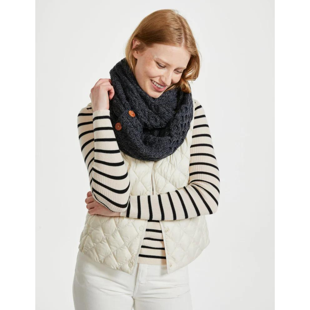 Smiling woman wearing a black knitted scarf and striped sweater