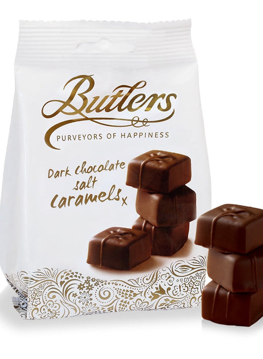 Butlers white bag of Dark Chocolate Salted Caramels with decorative pattern and chocolates beside.