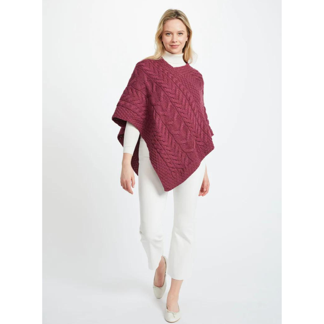 Woman wearing a purple knitted poncho with white pants and shoes