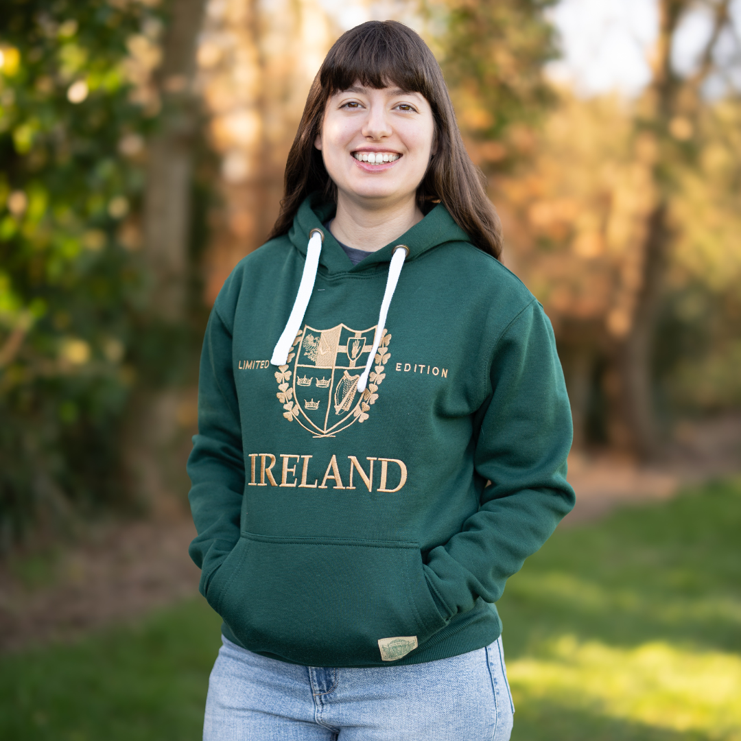 Smiling woman in green Ireland hoodie with crest outdoors
