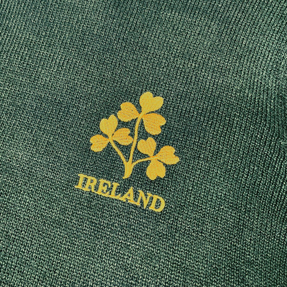 Close-up of bottle green knit fabric with a yellow shamrock bouquet and IRELAND text.
