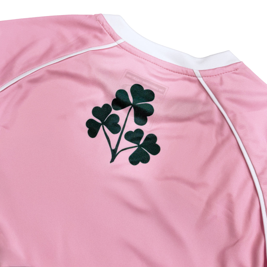 Back view of pink Lansdowne Ireland kids performance top with a dark green clover graphic.