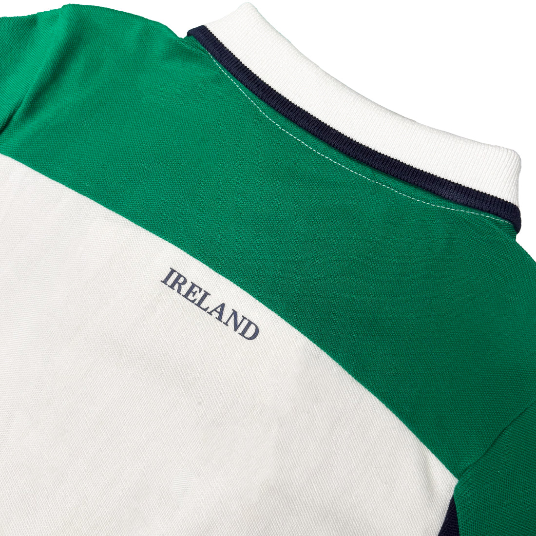 Back view of Lansdowne Ireland kids polo shirt showing green upper panel white section with Ireland text and navy trimmed collar