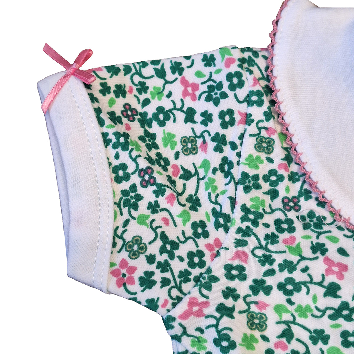 Close-up of a sleeve edge with a pink ribbon bow on the printed baby vest