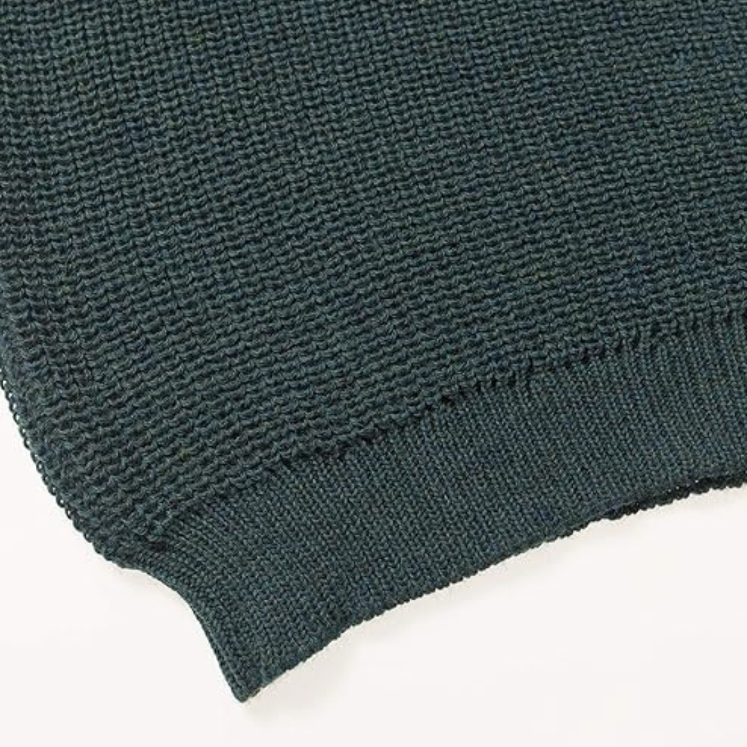 Close up of moss green fisherman's rib knit fabric on a men's Aran jumper