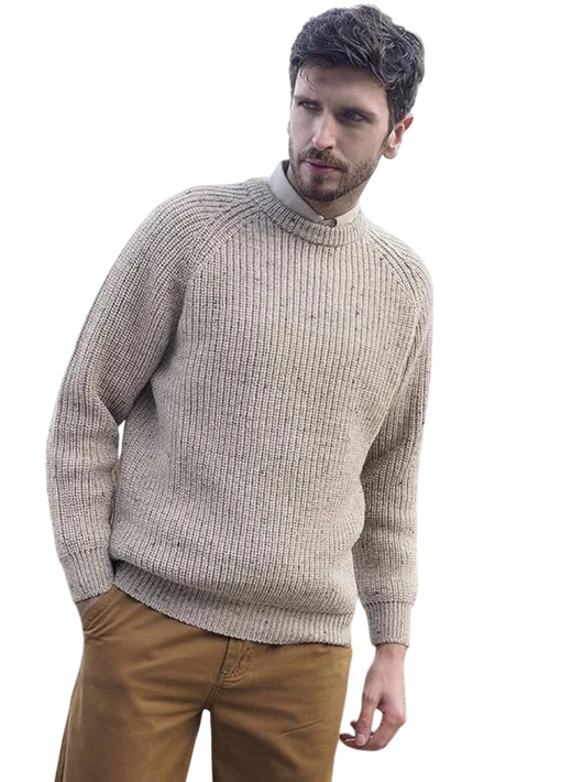 Male model wearing beige fisherman's ribbed Aran Skiddaw sweater with brown trousers.