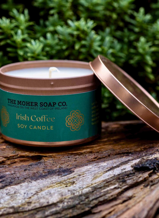 Copper tin candle labeled Irish Coffee soy candle on a rustic wood surface.