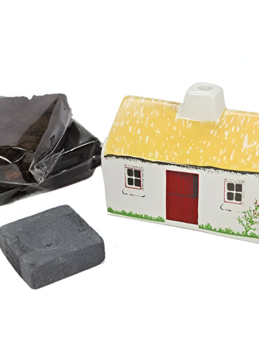 White cottage incense burner with a yellow roof and peat bricks