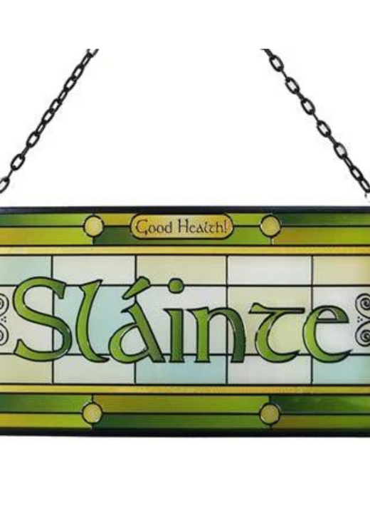 Stained glass sign with the word SlÃ¡inte and shamrock decorations