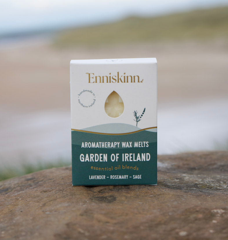 Enniskinn Garden of Ireland aromatherapy wax melts box with lavender rosemary sage notes placed on a rock by the sea.
