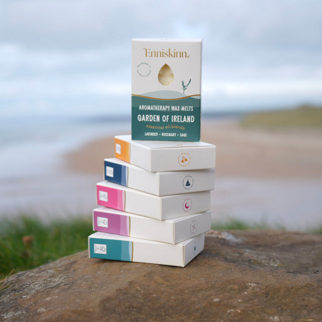 Enniskinn Garden of Ireland aromatherapy wax melts stacked boxes outdoors on a rock by the coast