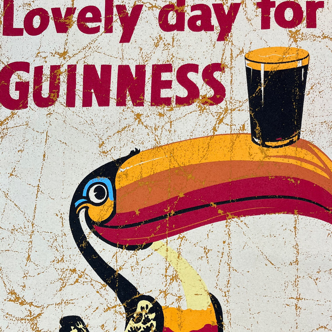 Close-up of the yellow Guinness tee graphic with a colorful toucan and a pint