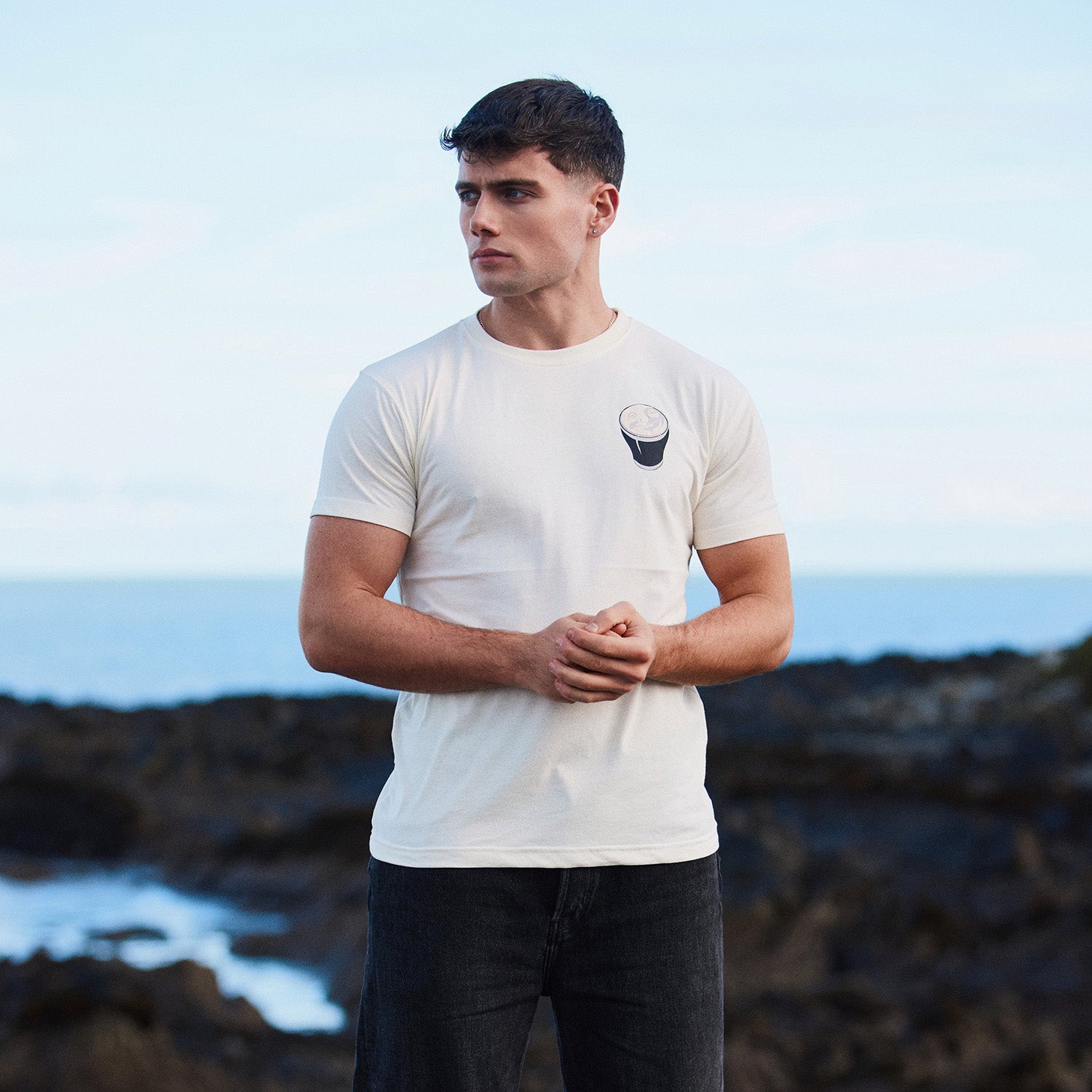 Man wearing white Guinness Smiling Pint T-shirt with small logo on chest