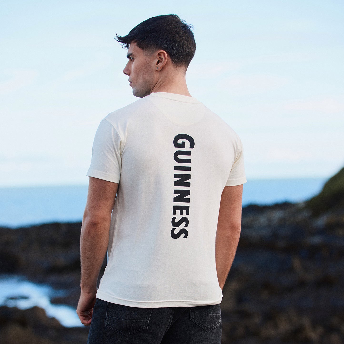 Back view of white Guinness Smiling Pint T-shirt with vertical GUINNESS text down the back