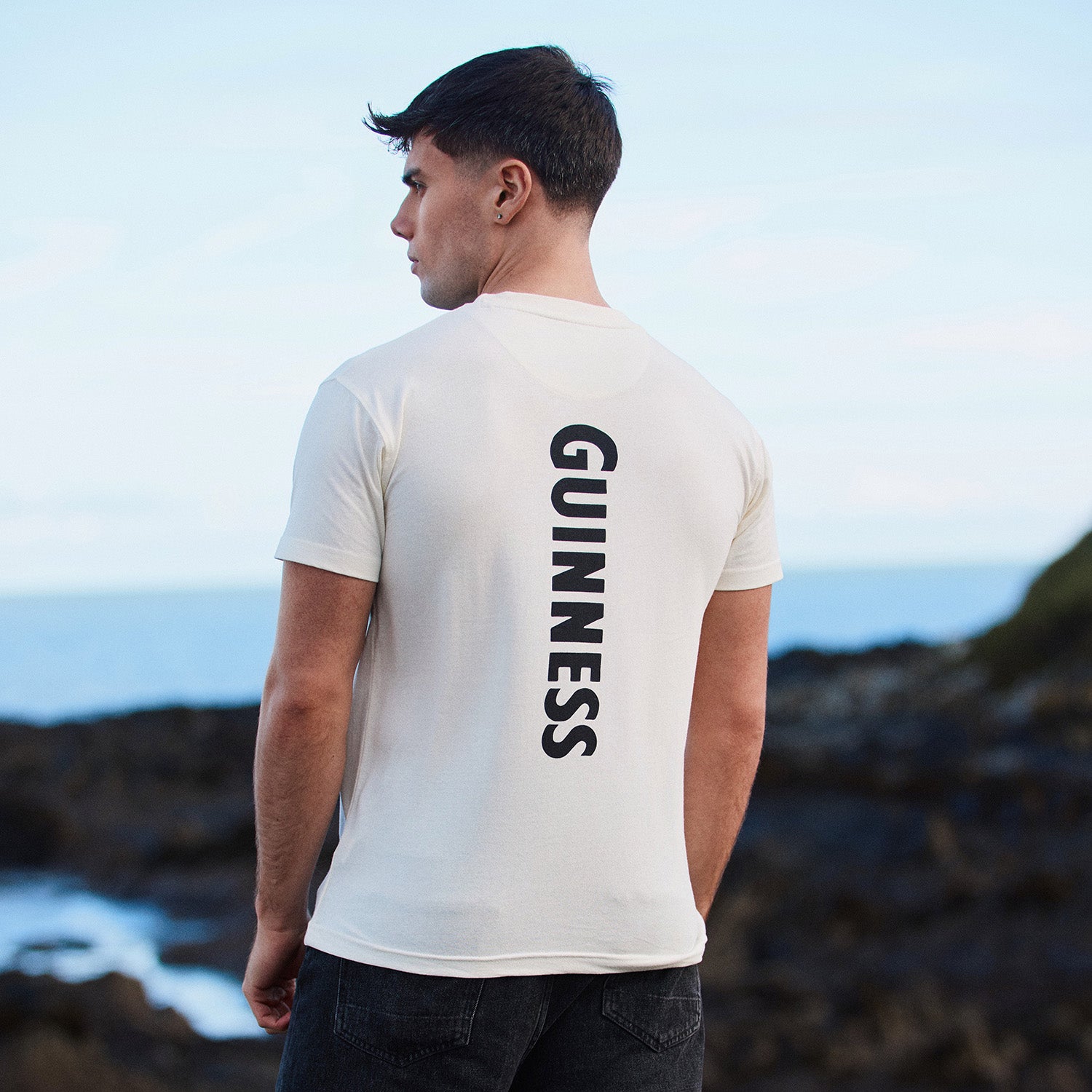 Back view of white Guinness Smiling Pint T-shirt with vertical GUINNESS text down the back