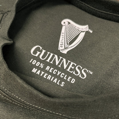 Close-up of the inner neck print on a dark fabric with the Guinness harp logo and the text 100% RECYCLED MATERIALS