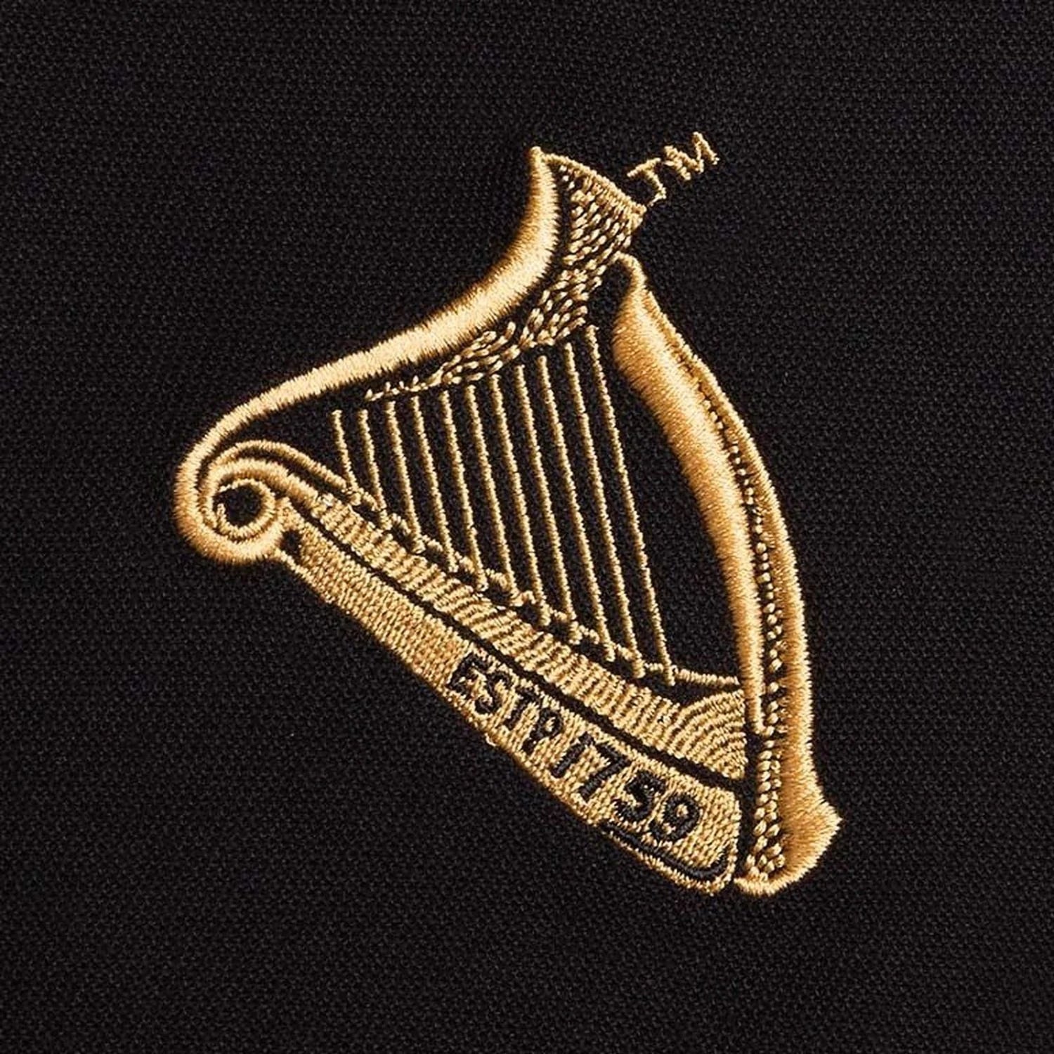 Gold embroidered harp logo on black polo fabric